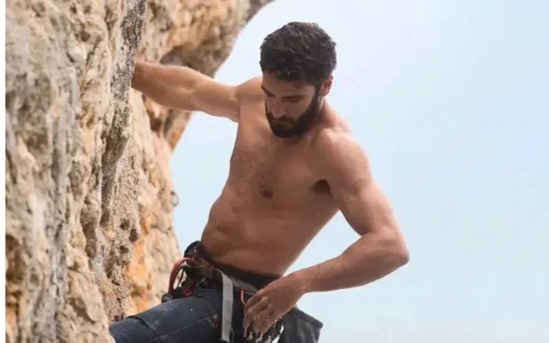 Climber assessing a bolted route before starting a sport climb