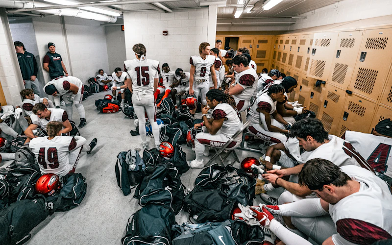 Use a Hanger to Declutter Football Gear in Locker Rooms | Heavy Duty Hangers by Tough Hook Football team getting ready in a locker room with gear bags and helmets on the floor