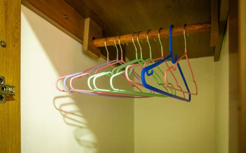 Hanger Durability Compared: Wood, Plastic, Metal & Heavy-Duty Options | Heavy Duty Hangers by Tough Hook Coated plastic hangers on a wooden closet rod