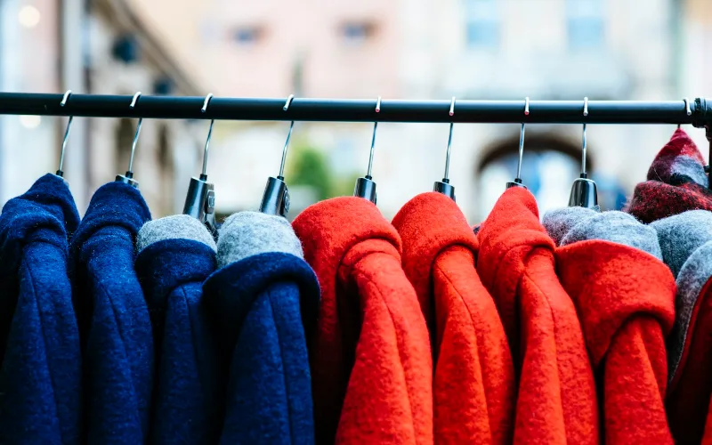 Hanger Durability Compared: Wood, Plastic, Metal & Heavy-Duty Options | Heavy Duty Hangers by Tough Hook Winter coats hanging on metal hangers on a steel rail